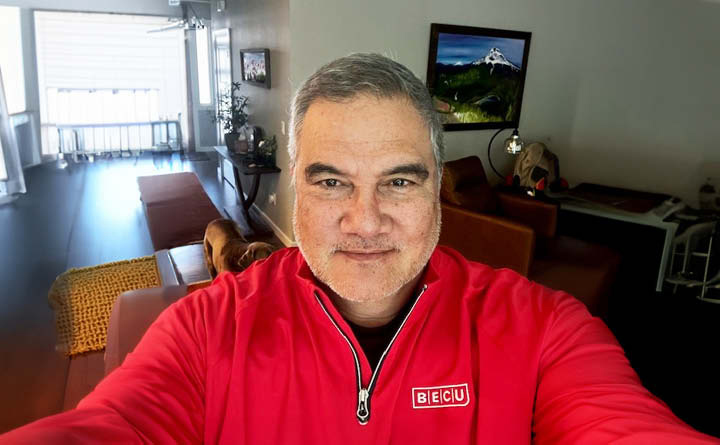 A headshot of BECU employee Rudy D. He is wearing a red BECU zip up coat.