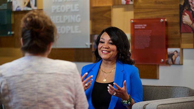 a woman in a blue jacket talking to a woman