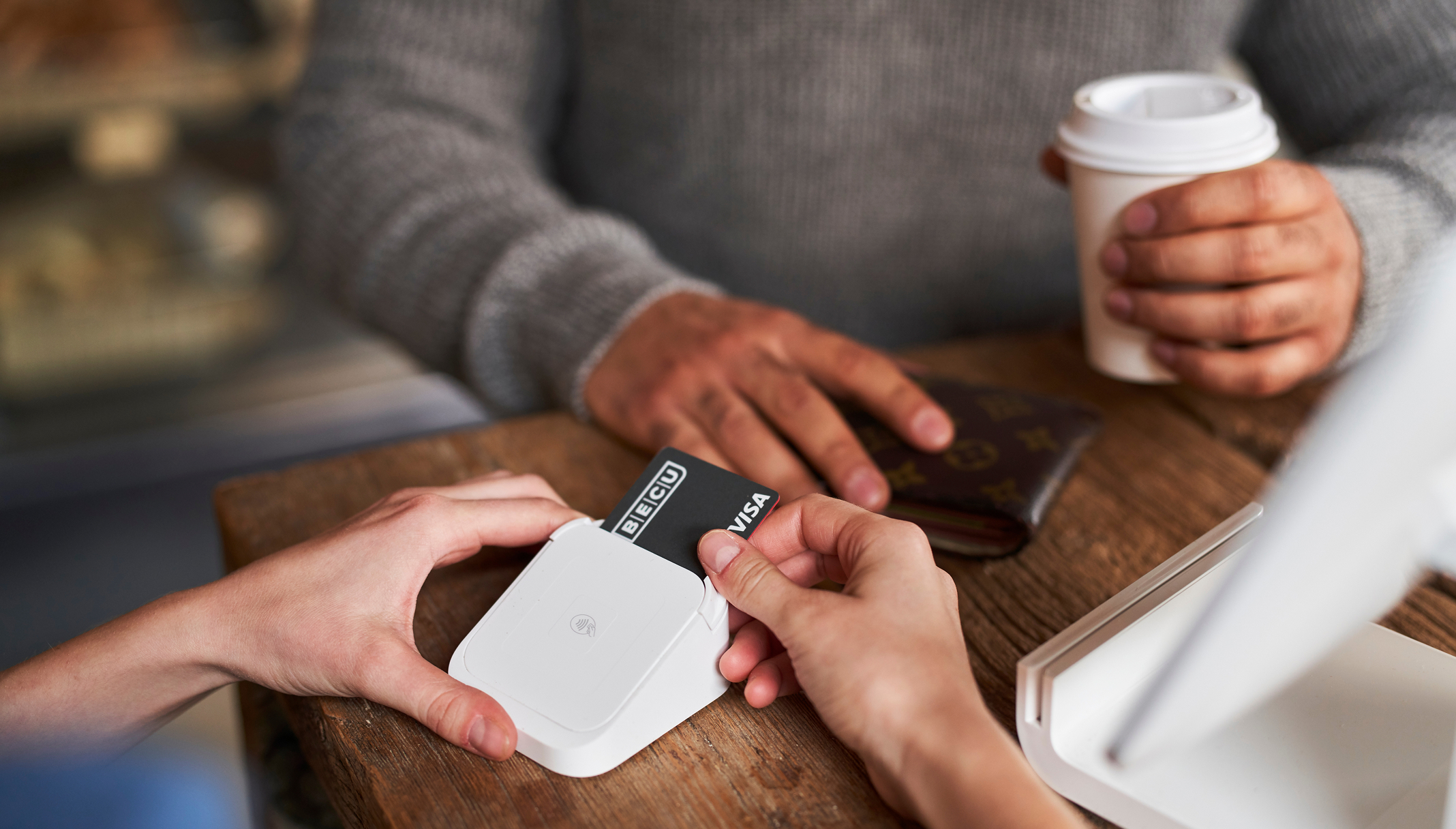 a person's hands inserting a credit card into a device