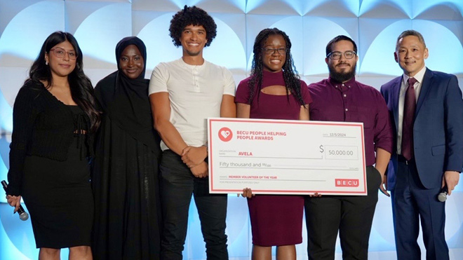 a group of people holding a check