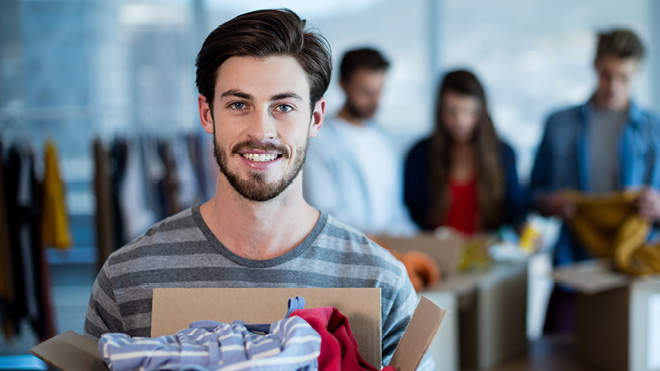 Man holding a box of donated clothing