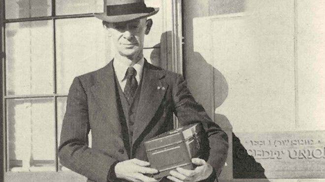 a man in a suit holding a box