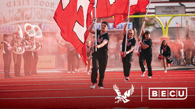 Easter Washington University marching band members and people carrying Eastern Washington University flags on a football field. Easter Washington University and BECU logos.