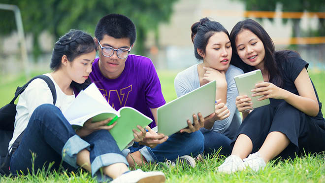 University of Washington students sitting on the grass reading books