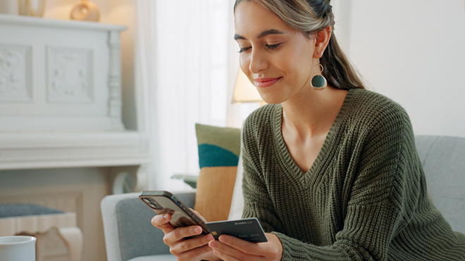 a woman holding a credit card and a phone