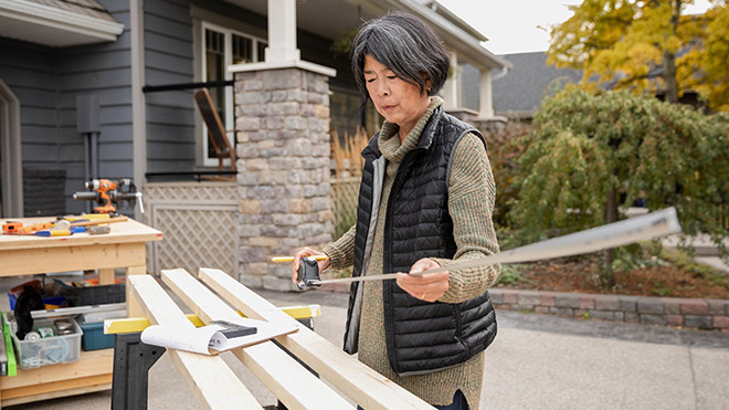 Woman measuring wood boards