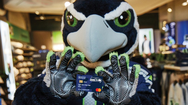 Seahawks mascot Blitz holding BECU Seahawk debit card