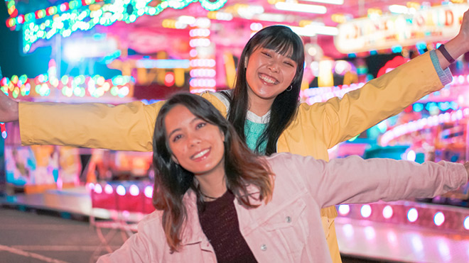 Two women posing and smiling for a picture at the Washington State Fair.