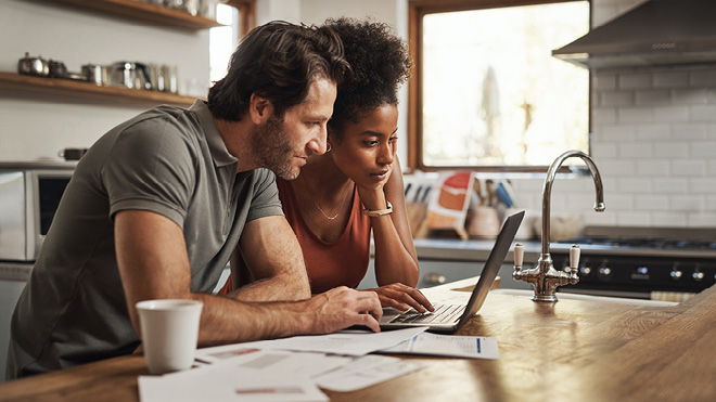 a man and woman looking at a laptop