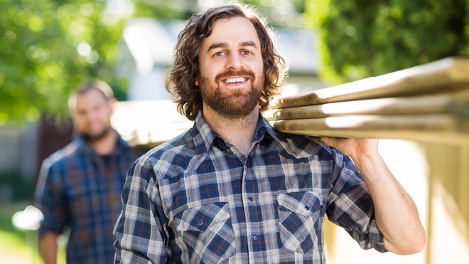 a man carrying a stack of wood