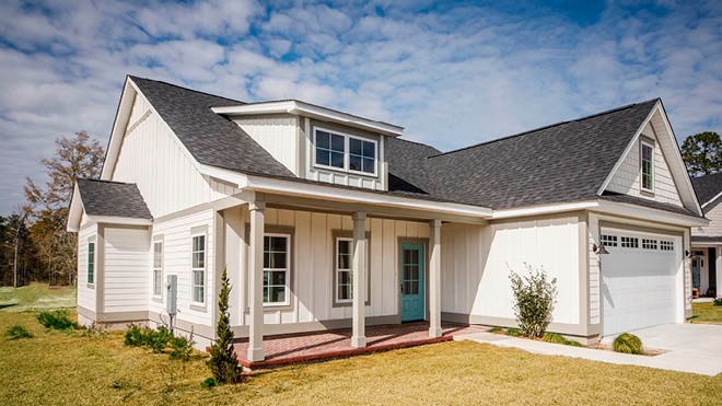 A beautiful, white home featuring a front porch and pitched roofs