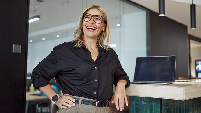 A smiling woman with her laptop.