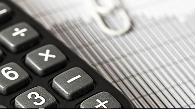 Calculator paper clip and pen on a table