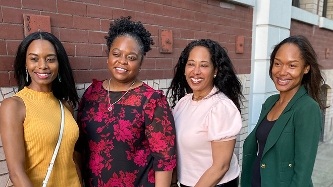 Four Black women, founders of the Black Futures Co-op Fund, stand outside together and smile for a photo.