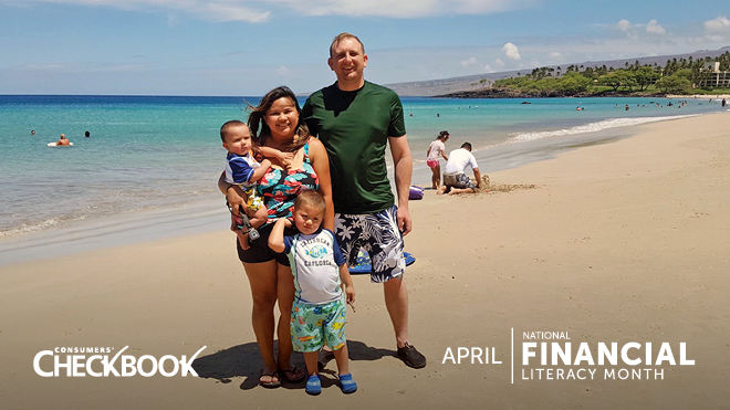 Parents stand smiling with their two young children on a sunny, sandy beach with bright blue water behind them. A white logo on the lower left of the image says: "Consumers' Checkbook." A white logo on the lower right says: "April: National Financial Literacy Month."