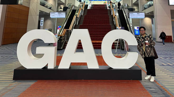Large GAC event letters displayed in a conference setting, with a BECU employee posing next to the letters. 