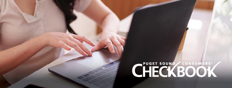 Close-up of hands typing on a laptop at a desk. The Consumers' Checkbook logo is overlaid on the image.
