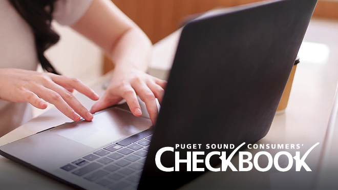 Close-up of hands typing on a laptop at a desk. The Consumers' Checkbook logo is overlaid on the image.