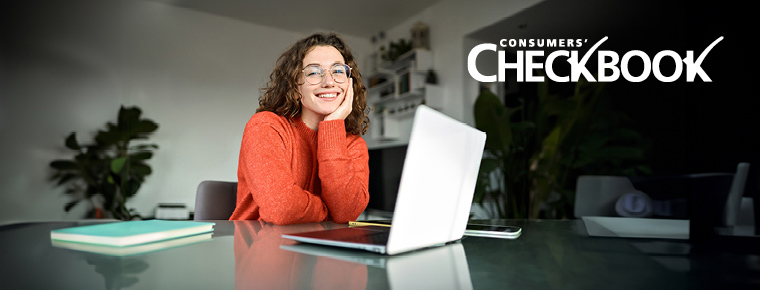 A woman sits at a kitchen counter with a laptop open in front of her. The Consumers’ Checkbook logo appears in the upper right corner.