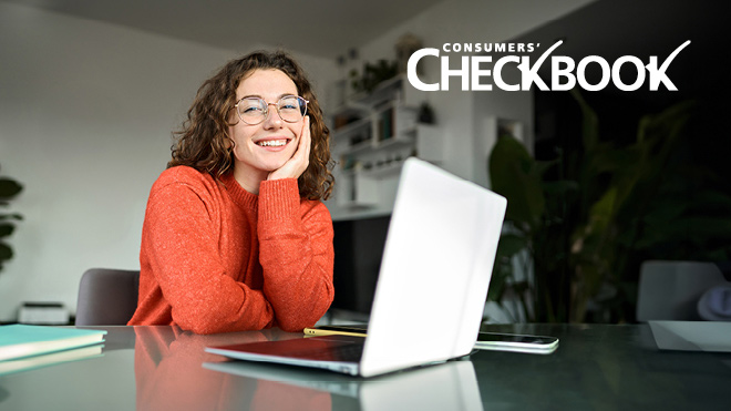 A woman sits at a kitchen counter with a laptop open in front of her. The Consumers’ Checkbook logo appears in the upper right corner.