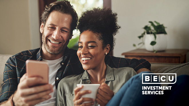 A smiling man and woman looking at a phone. BECU Investment Services.