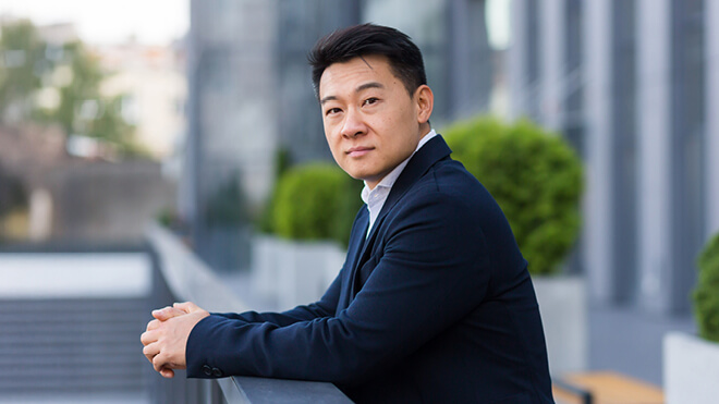 A man wearing a suit outside of a office building.