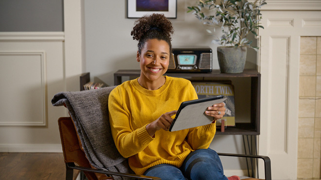 A smiling woman with a tablet.