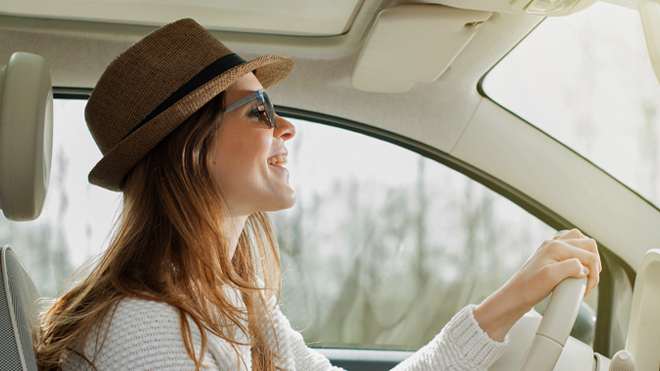 A smiling woman driving a car