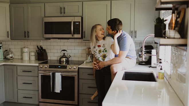 a man holding a woman in a kitchen