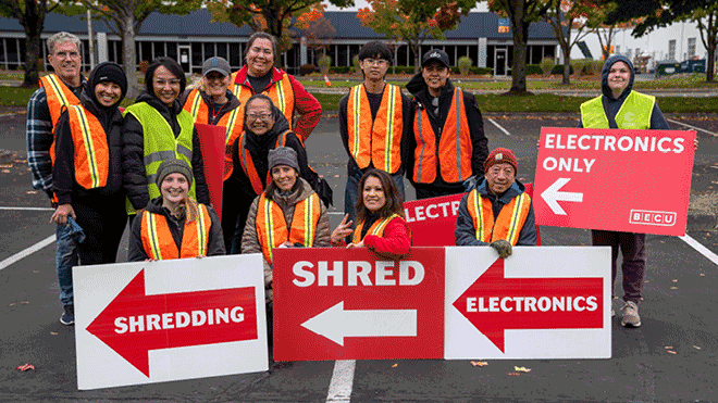 a group of people in orange vests holding signs