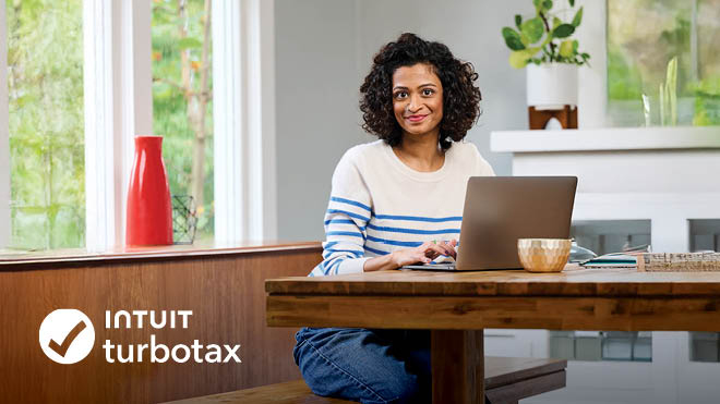 A smiling woman working on her laptop. Intuit TurboTax logo.
