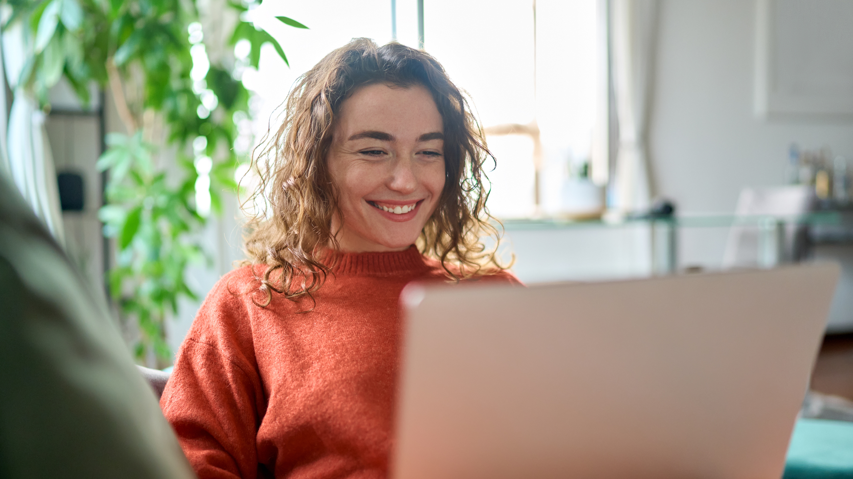 Smiling woman working on a laptop computer