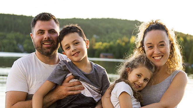 Parents and young children on front of a lake