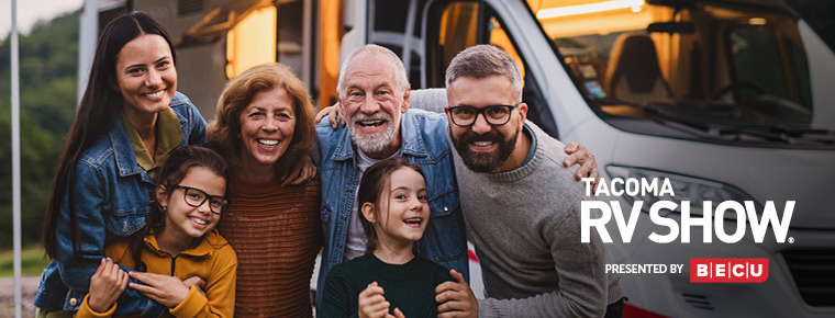 A group of people smiling in front of an RV.