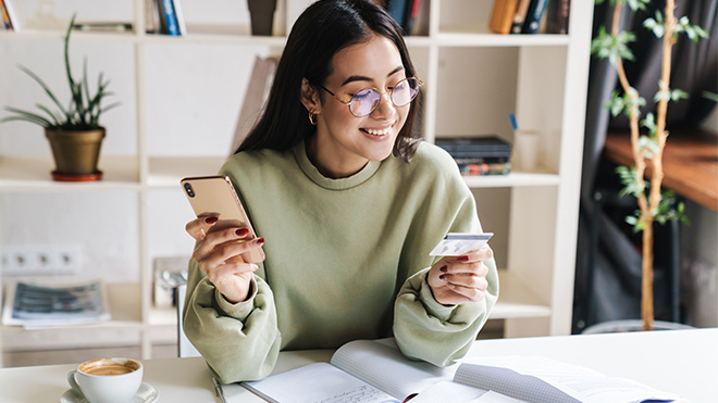 Young adult woman looking at credit card