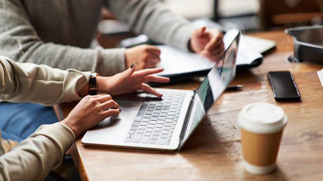 Image shows  a young person's hands on a laptop. 