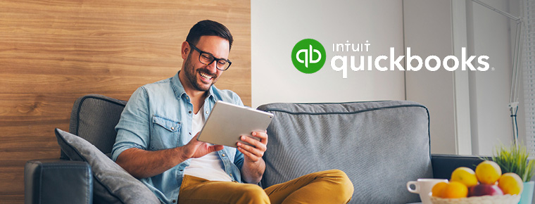 A smiling man looking at a tablet screen. Intuit Quickbooks logo.