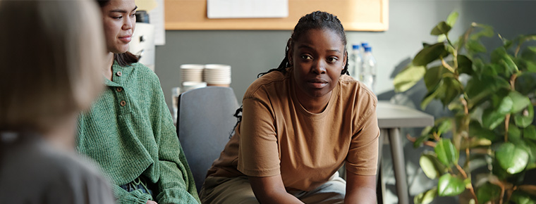 Three people having a conversation while sitting.