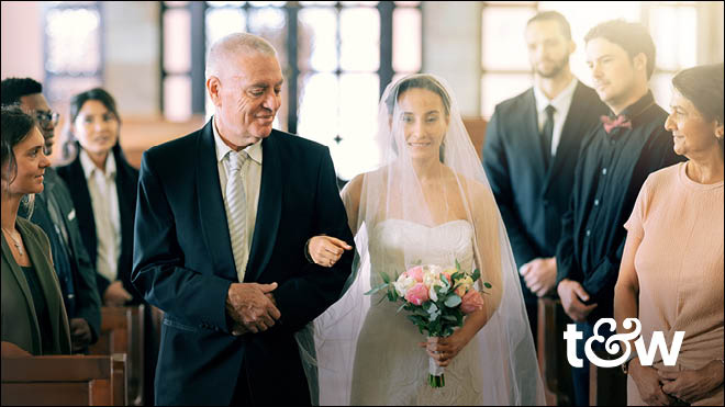 A man walking his daughter down the aisle during a wedding. Trust & Will logo.