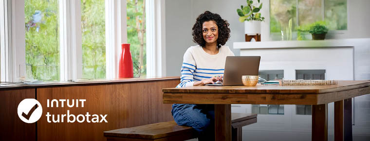 A smiling woman working on her laptop. Intuit TurboTax logo.