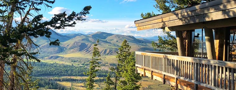 A balcony overlooking a forest and mountains.