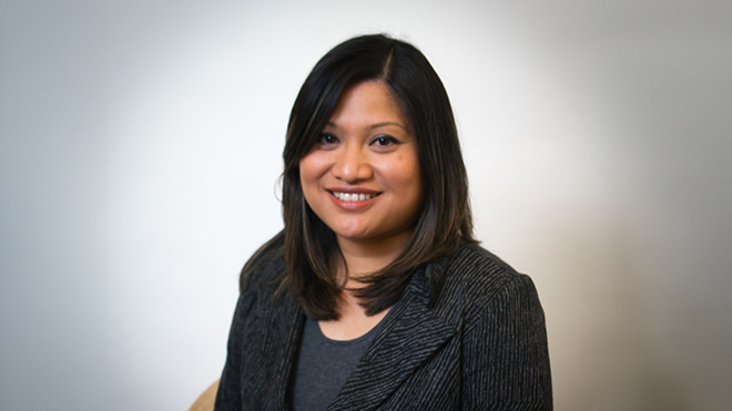 A headshot of BECU employee Olivia Simon. She's wearing a black blazer and is posing in front of a white backdrop. 