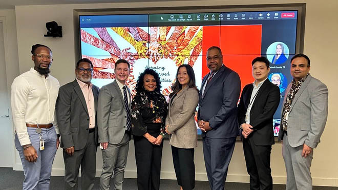 BECU's 2023 Multicultural Emerging Leaders (MEL) Program pose in front of a PowerPoint presentation. There are eight employees in the group photo.