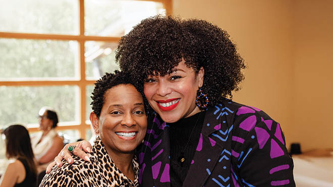 CEO Beverly Anderson and BECU employee Sacheen W. The two are smiling and sharing a side hug.