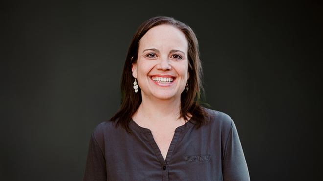 A professional headshot of BECU employee Stacey Black. She's smiling against a dark gray solid background.