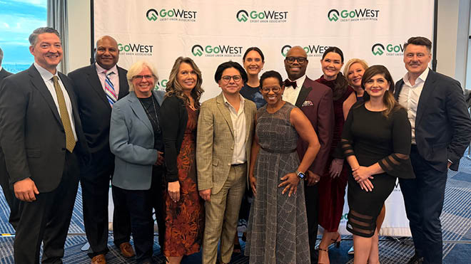 Group photo of BECU employees standing in front of a white GoWest Credit Union Association-branded backdrop.