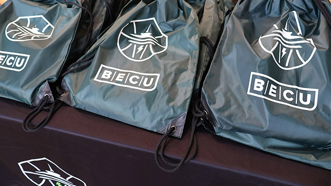 Black promotional bags featuring BECU and Seattle Storm branding.