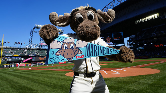 The Mariner Moose holds a Mariners pennant with the BECU logo on the field at T-Mobile stadium.