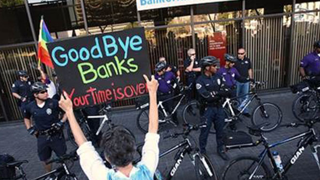 A person holding a sign that says, "Goodbye Banks"
