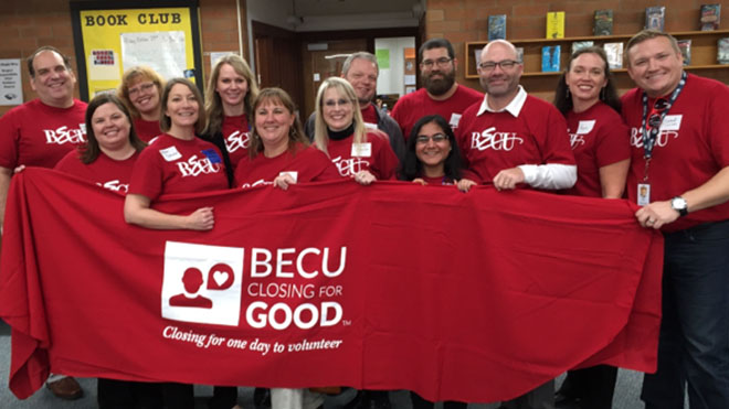 A group of BECU employees holding red banner that says, Closing for Good, a community outreach effort